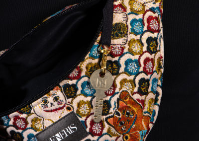Sac banane à motifs chats. Doublure noire. Collection Vigiliis Noctis Neko. Crochet pour accessoire (clé, porte cartes...). Etiquette VENERIS noire. Sangle noire. Rivets de décoration.