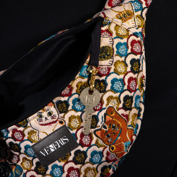 Sac banane à motifs chats. Doublure noire. Collection Vigiliis Noctis Neko. Crochet pour accessoire (clé, porte cartes...). Etiquette VENERIS noire. Sangle noire. Rivets de décoration.