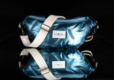 Sac banane en tissu matelassé métallisé. Doublure grise à motifs. Collection Vigiliis Noctis Blue Nebula. Etiquette VENERIS blanche. Sangle blanche. Rivets de décoration.