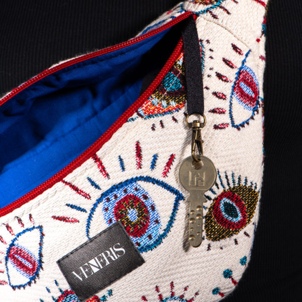 Sac banane à motifs yeux. Doublure bleu roi. Collection Vigiliis Noctis Oculus. Crochet pour accessoire (clé, porte cartes...). Etiquette VENERIS noire. Sangle noire. Rivets de décoration.