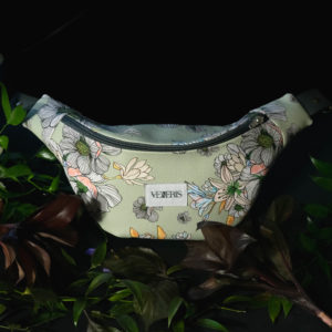 Sac banane à fleurs en simili cuir vert pastel. Doublure noire. Collection Vetus et Novum Papaver rhoeas. Etiquette VENERIS blanche. Sangle grise. Rivets de décoration.