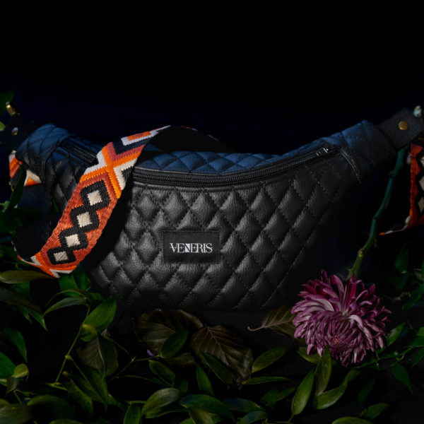 Sac banane en similicuir matelassé noir. Doublure à fleurs récupérée d'un blouson. Collection Vetus et Novum Crystallini. Etiquette VENERIS noire. Sangle à motifs. Rivets de décoration.