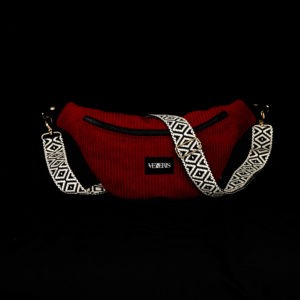 Sac banane rouge réalisé avec du velours côtelé (grosse côtes). Doublure noire. Collection LET IT SNOW Cosy n°4. Etiquette VENERIS noire. Sangle à motifs. Rivets de décoration.