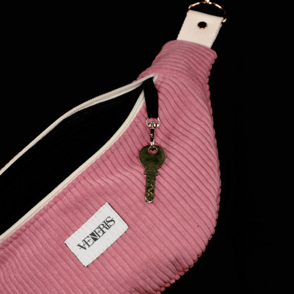 Sac banane rose réalisé avec du velours côtelé (grosse côtes). Doublure grise foncée. Collection LET IT SNOW Cosy n°6. Crochet pour accessoire (clé, porte cartes...). Etiquette VENERIS noire. Rivets de décoration.