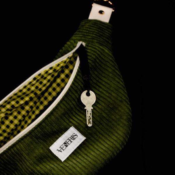 Sac banane vert olive réalisé avec du velours côtelé (grosse côtes). Doublure récupérée de housse de duvet. Collection LET IT SNOW Cosy n°5. Crochet pour accessoire (clé, porte cartes...). Etiquette VENERIS blanche. Rivets de décoration.