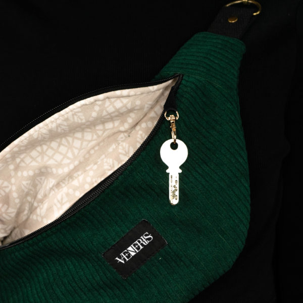 Sac banane vert sapin réalisé avec du velours côtelé (grosse côtes). Doublure récupérée de housse de duvet. Collection LET IT SNOW Cosy n°3. Crochet pour accessoire (clé, porte cartes...). Etiquette VENERIS noire. Rivets de décoration.
