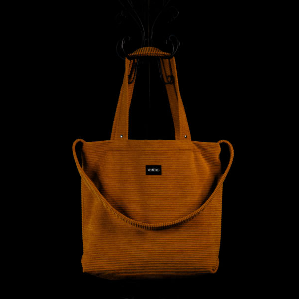 Tote bag ocre en velours côtelé (grosse côtes). Collection LET IT SNOW Cosy n°1. Trois anses réalisées avec le même tissu. Rivets de décoration à chaque extrémité des petites sangles. Ce modèle est conçu avec une troisième anse plus longue pour porter le sac aussi en bandoulière. Etiquette VENERIS noire.