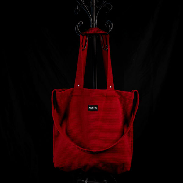 Tote bag rouge en velours côtelé (grosse côtes). Collection LET IT SNOW Cosy n°4. Trois anses réalisées avec le même tissu. Rivets de décoration à chaque extrémité des petites sangles. Ce modèle est conçu avec une troisième anse plus longue pour porter le sac aussi en bandoulière. Etiquette VENERIS noire.