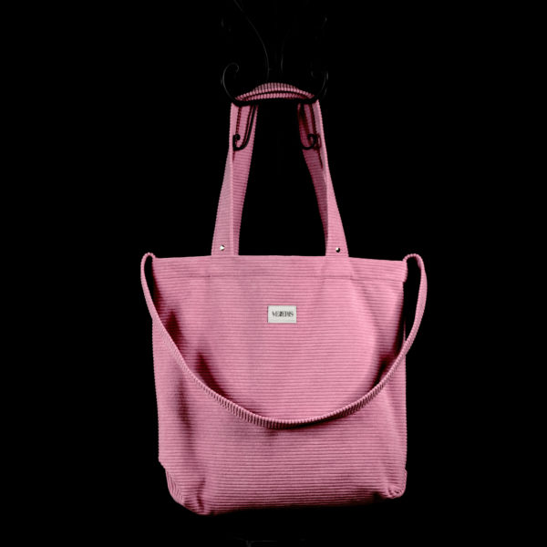 Tote bag rose en velours côtelé (grosse côtes). Collection LET IT SNOW Cosy n°6. Trois anses réalisées avec le même tissu. Rivets de décoration à chaque extrémité des petites sangles. Ce modèle est conçu avec une troisième anse plus longue pour porter le sac aussi en bandoulière. Etiquette VENERIS blanche.