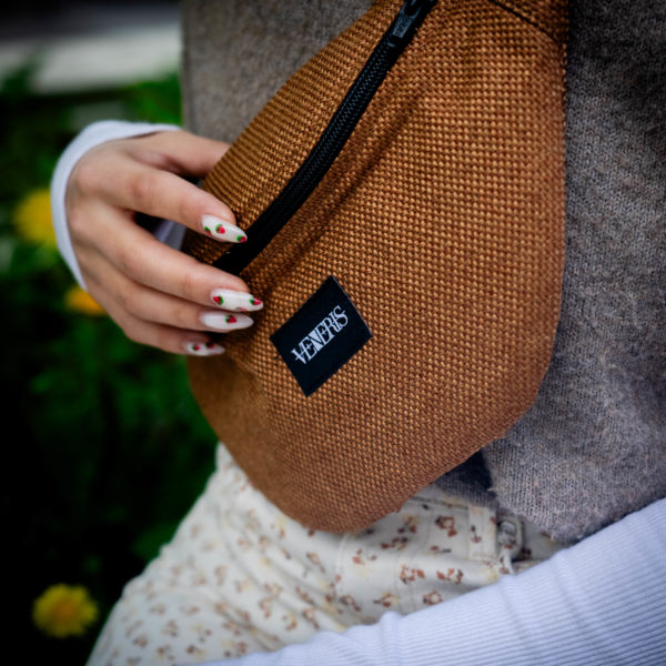 Sac banane ocre réalisé avec un reste de rideau. Doublure à motif. Collection ÉLÉMENTAIRE. Etiquette VENERIS noire. Rivets de décoration. Sangle noire